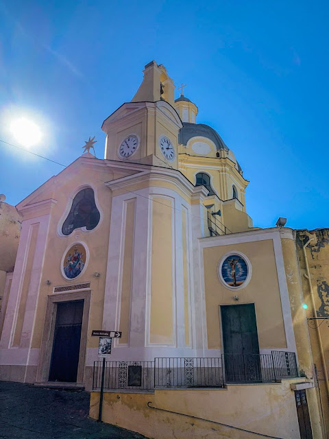 a church with bell tower with yellow facade and white decorative elements