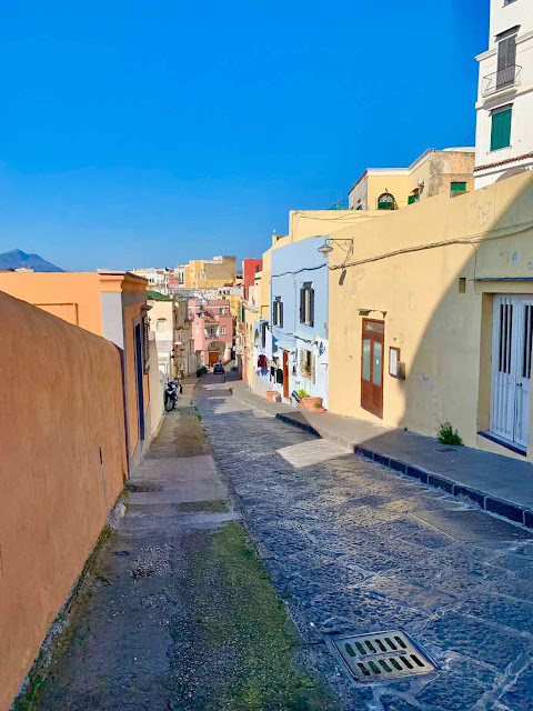 a narrow alley crosses colored houses